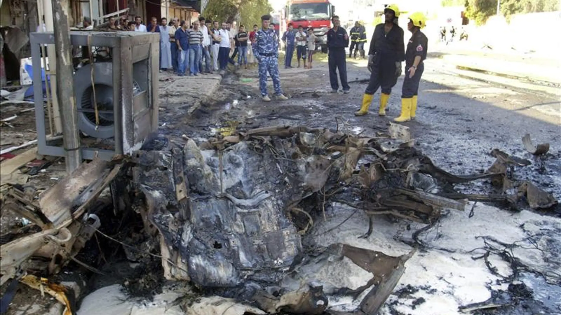 Policías iraquíes inspeccionan los daños causados tras un atentado en Irak. Policías iraquíes inspeccionan los daños causados tras un atentado en Irak.