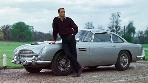 James Bond con su Aston Martin James Bond con su Aston Martin