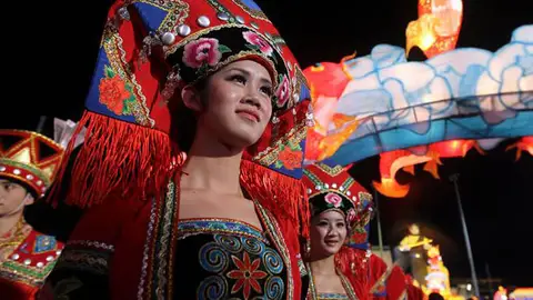 Una mujer con el traje tradicional da la bienvenida a las celebraciones de la víspera Una mujer con el traje tradicional da la bienvenida a las celebraciones de la víspera