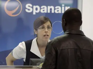 Una empleada de Spanair atiende en uno de los mostradores Una empleada de Spanair atiende en uno de los mostradores