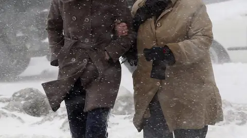 Dos mujeres cruzan una calle bajo la ventisca en Pristina, en la región de Kosovo Dos mujeres cruzan una calle bajo la ventisca en Pristina, en la región de Kosovo