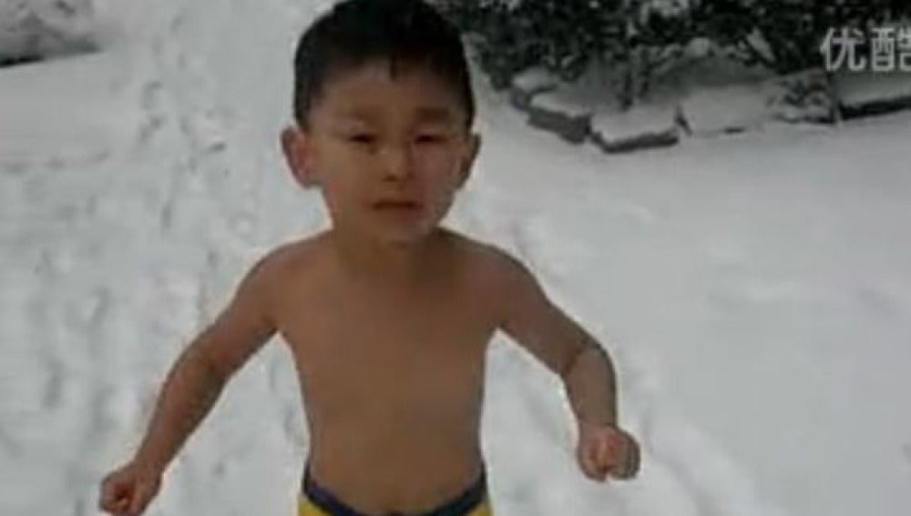 Niño chino corriendo en la nieve