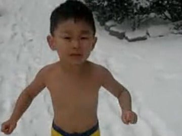 Niño chino corriendo en la nieve