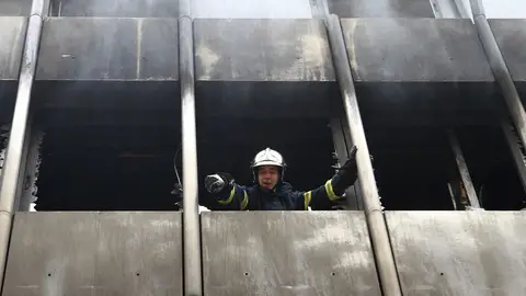 Un bombero trabaja en un edificio incendiado Un bombero trabaja en un edificio incendiado