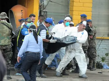 Los forenses con el cuerpo de una de las víctimas Los forenses con el cuerpo de una de las víctimas