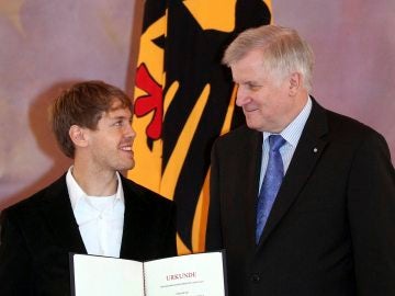 El primer ministro bávaro. Horst Seehofer, entrega la condecoración a Vettel