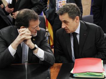 El primer ministro español, Mariano Rajoy (i), charla con el presidente francés, Nicolas Sarkozy