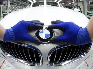 Un empleado coloca la insignia de BMW en un vehículo 