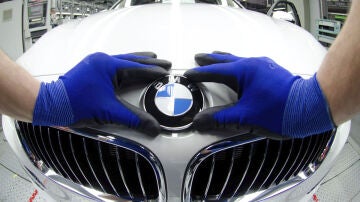 Un empleado coloca la insignia de BMW en un vehículo 
