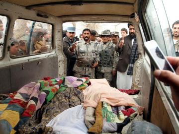  Personas muestran los cadáveres de afganos asesinados presuntamente por un soldado estadounidense