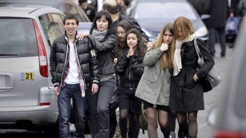 Un grupo de adolescentes llora en el exterior de la escuela jud&iacute;a "Ozar Hatorah