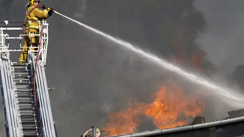 Un bombero echa agua sobre el incendio de la fábrica de puertas "Portas Vilanova" Un bombero echa agua sobre el incendio de la fábrica de puertas "Portas Vilanova"