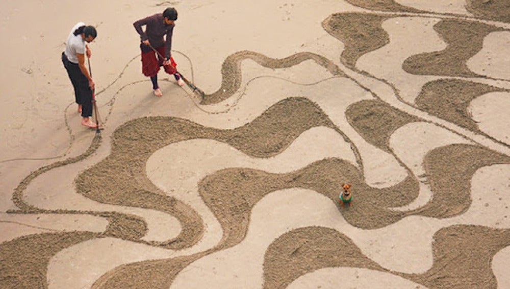 Andrés Amador pintando sobre la arena