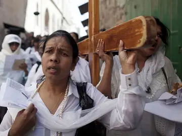 Varios peregrinos portan una cruz mientras participan en el Vía Crucis Varios peregrinos portan una cruz mientras participan en el Vía Crucis