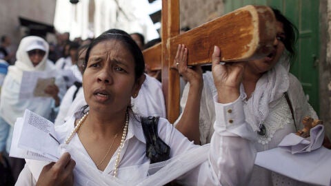 Varios peregrinos portan una cruz mientras participan en el V&iacute;a Crucis 