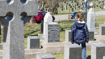 Un turista contempla una de las 121 tumbas de víctimas del Titanic