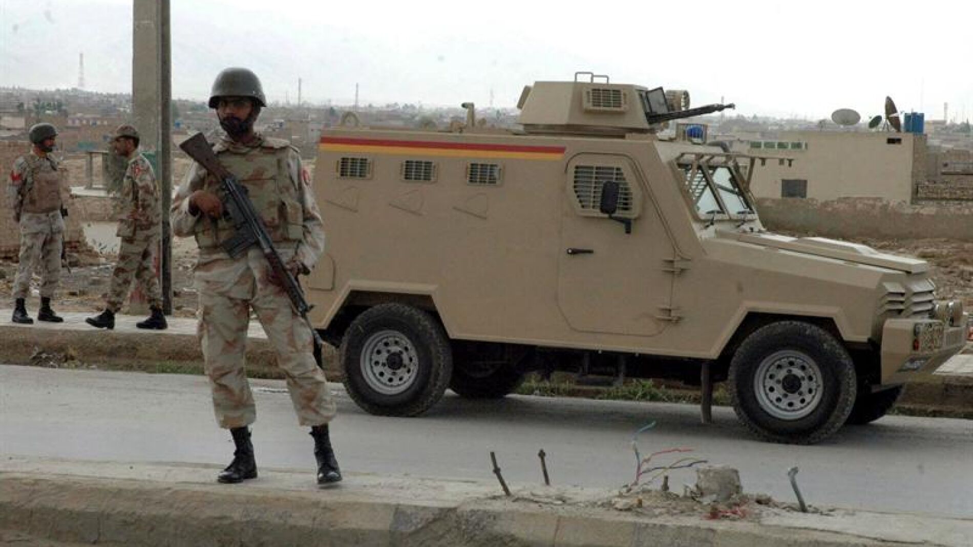 Polic&iacute;as paquistan&iacute;es hacen guardia en un punto de control en una carretera