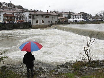 Una persona observa la crecida del río Esca en Navarra