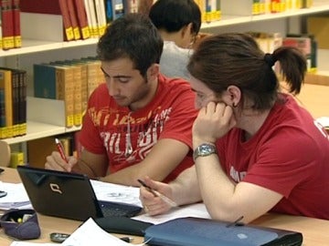 Dos jóvenes estudian en una biblioteca