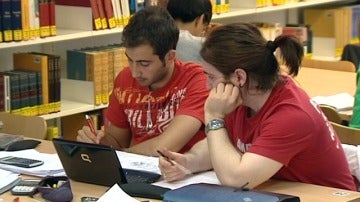 Dos jóvenes estudian en una biblioteca