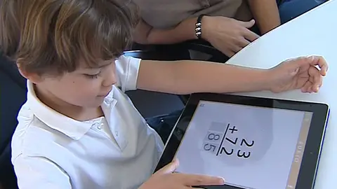 Un niño con el cuaderno Rubio en una tablet Un niño con el cuaderno Rubio en una tablet