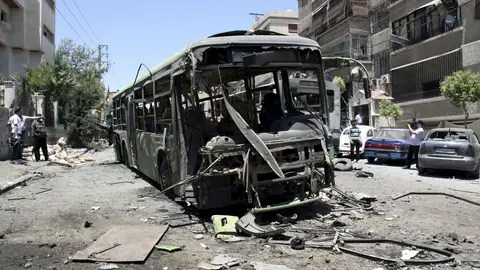 Oficiales de seguridad inspeccionan la zona donde ha explosionado un vehículo policial Oficiales de seguridad inspeccionan la zona donde ha explosionado un vehículo policial