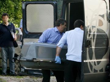 Miembros de servicios funerarios trasladan un cuerpo sin vida Miembros de servicios funerarios trasladan un cuerpo sin vida