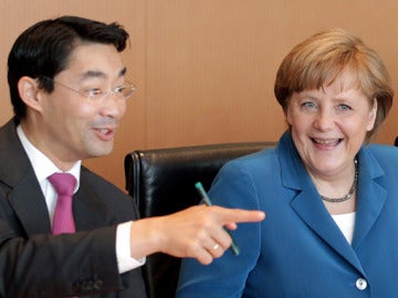 Angela Merkel conversa con el ministro de Economía, Philipp Rösler