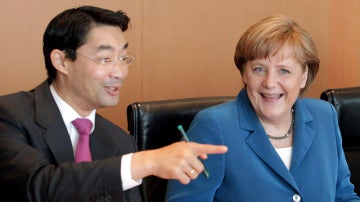 Angela Merkel conversa con el ministro de Economía, Philipp Rösler