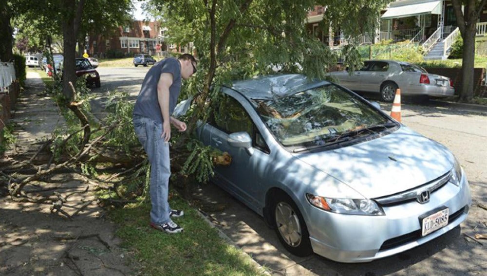 Un ciudadano observa los desperfectos ocasionados en su coche