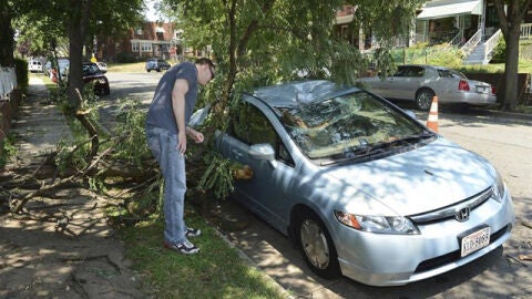 Un ciudadano observa los desperfectos ocasionados en su coche