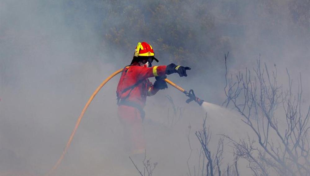Un bombero intenta apagar el fuego en Valencia