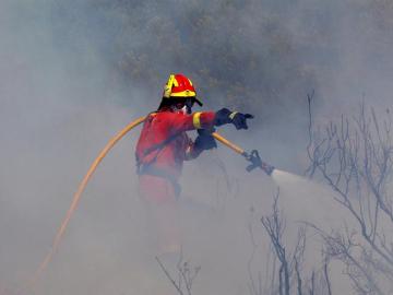 Un bombero intenta apagar el fuego en Valencia