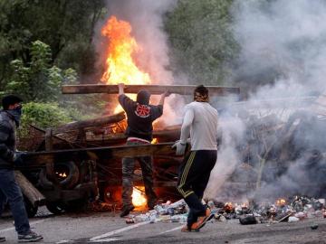 Varios mineros cortan una carretera con una barricada