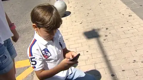 Niño utilizando un móvil Niño utilizando un móvil