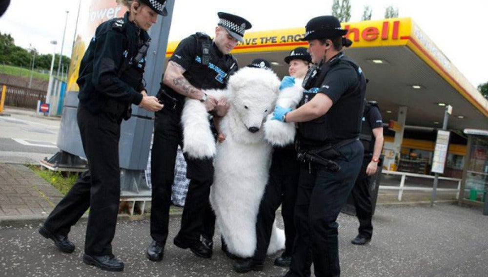 La policía británica detiene a un manifestante disfrazado de oso.