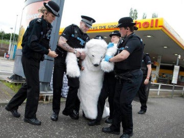 La policía británica detiene a un manifestante disfrazado de oso.