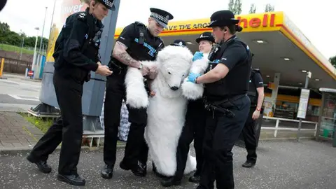 La policía británica detiene a un manifestante disfrazado de oso. La policía británica detiene a un manifestante disfrazado de oso.