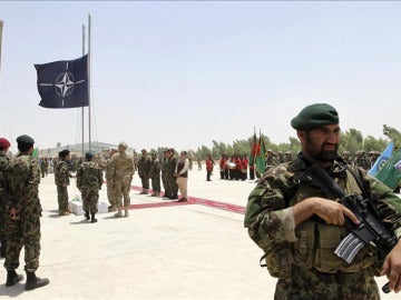 Soldados en Afganistán con la bandera de la OTAN al fondo