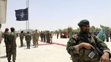 Soldados en Afganistán con la bandera de la OTAN al fondo