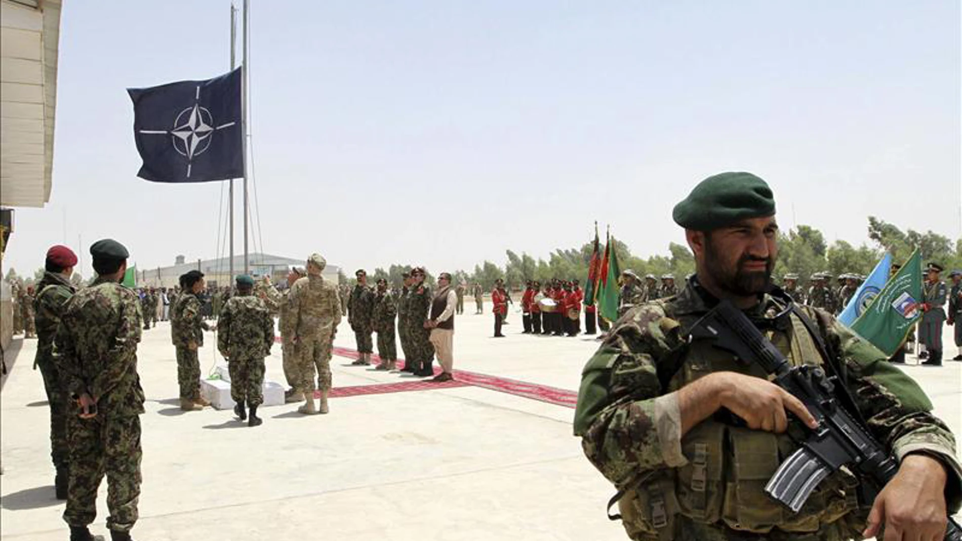 Soldados en Afganistán con la bandera de la OTAN al fondo Soldados en Afganistán con la bandera de la OTAN al fondo