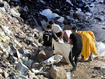 Personas llevan cuerpos mutilados a un cementerio en el área de Yalda, 10 kilómetros al sur de Damasco