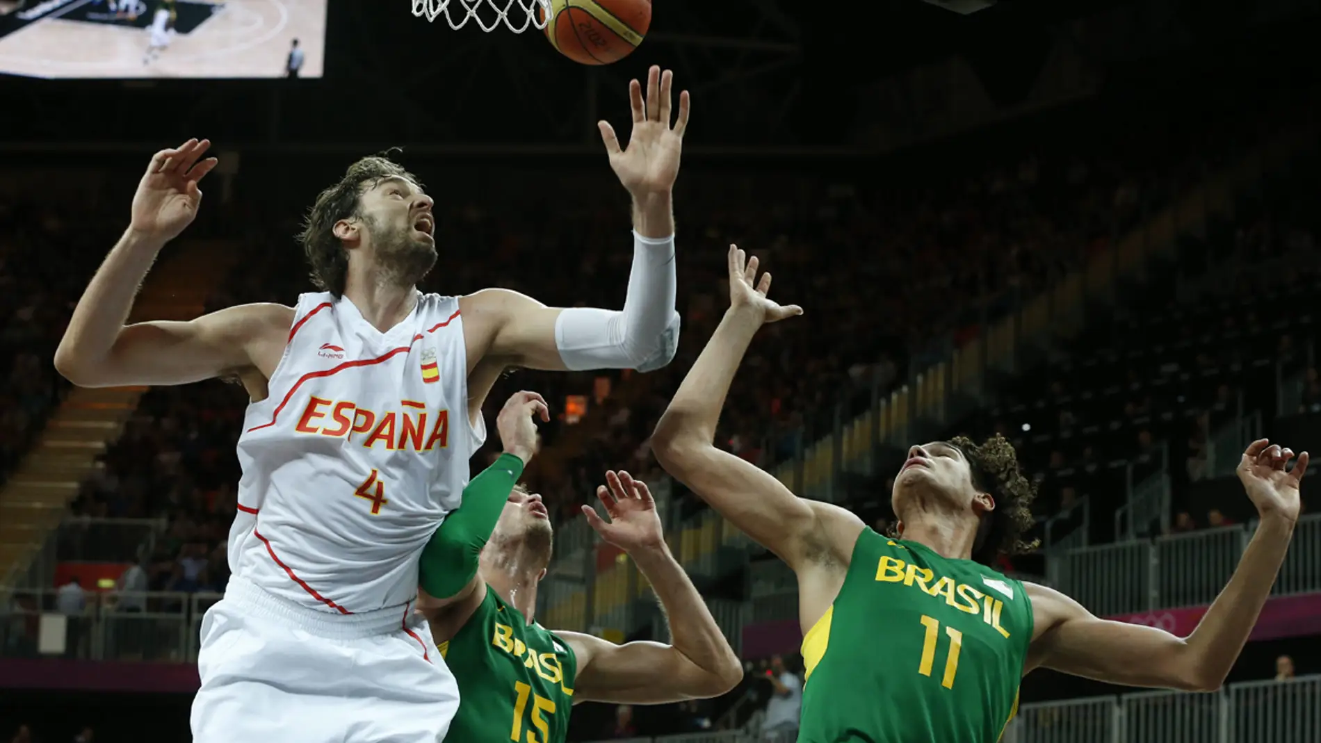 Pau Gasol trata de capturar un rebote ante Splitter y Varejai