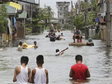 Varias personas nadan por las calles inundadas de Malabón Varias personas nadan por las calles inundadas de Malabón