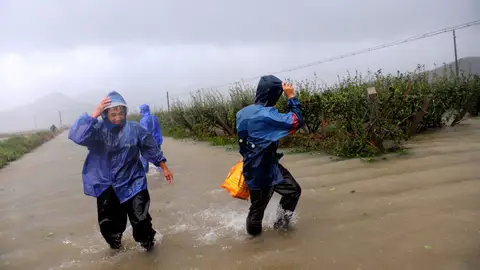 Granjeros intentan proteger sus estanques en una granja acuática inundada Granjeros intentan proteger sus estanques en una granja acuática inundada