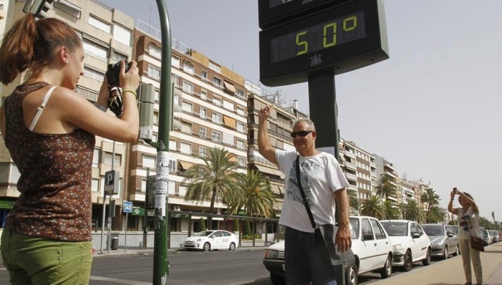 Turistas se fotografían con un termómetro