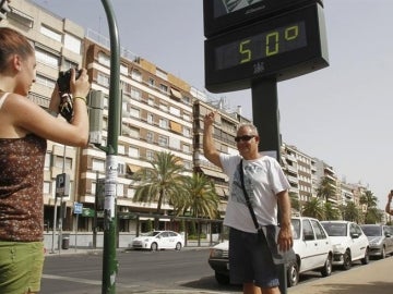 Turistas se fotografían con un termómetro