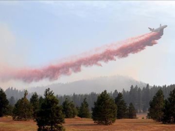 Un avión libera retardante para combatir un incedio