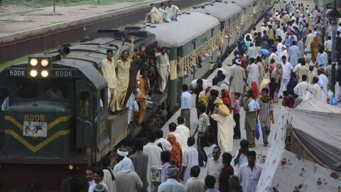 Varias personas se suben a un tren para acudir a la festividad religiosa del 'Aid el Fitr' en Pakist&aacute;n