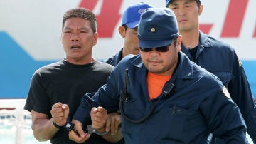 Policías japoneses escoltan a un activista de Hong Kong detenido por la guardia costera de Japón tras desembarcar en las islas Diaoyu, en chino, o Senkaku, en japonés